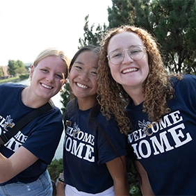 Three smiling students wearing 