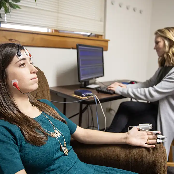 Female with her fingers hooked up to electronic monitoring.