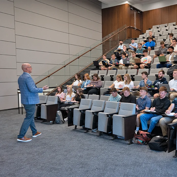 Professor standing in front of classroom teaching.