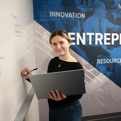 A girl stands at a whiteboard