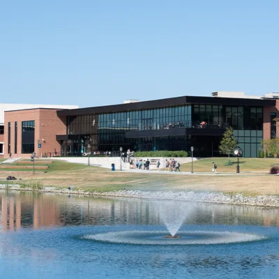 Outside of Scharnberg Business and Communication Center with lake and fountain in foreground.