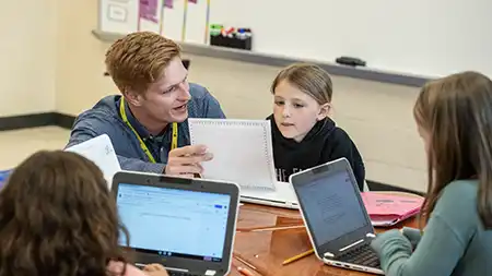 Male teacher educating a small group of children.