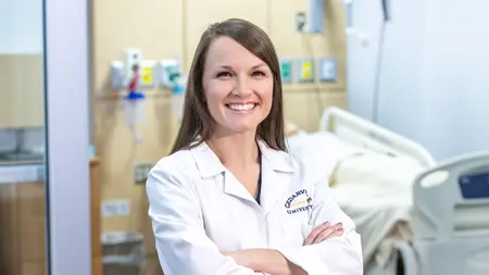 Female nursing faculty wearing a white lab coat.