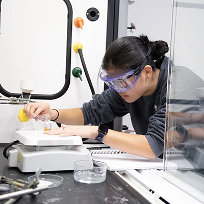 Student working in a lab with scientific equipment.