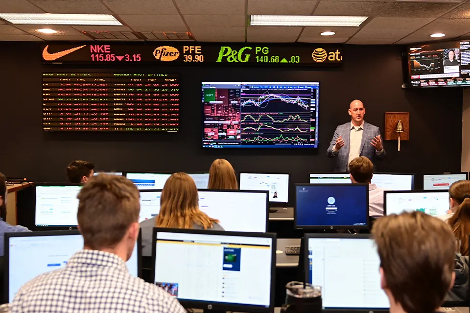 Business professor explaining stock market chart to students