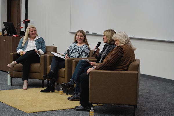 Four women speaking in front of an audience