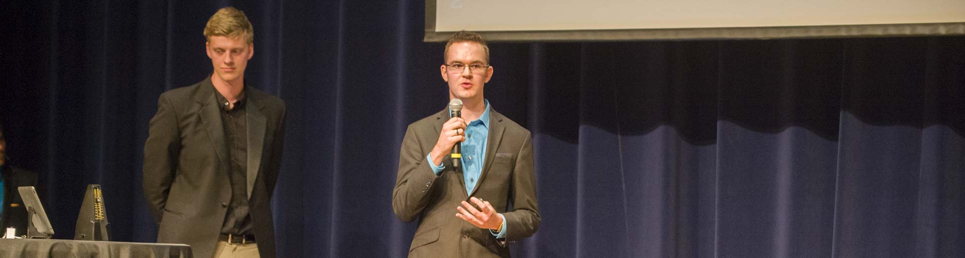 Joel Kendall on stage presenting Homework Muffin at The Pitch.