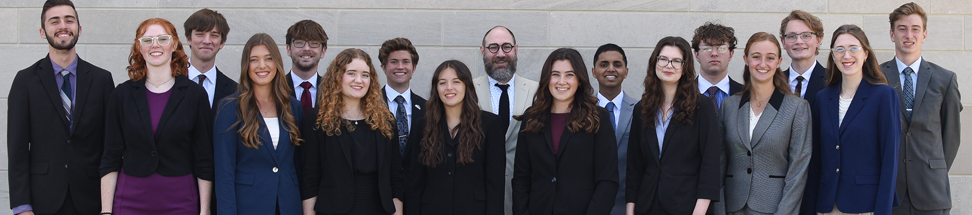 16 students who make up the Cedarville University speech and debate team with their coach.