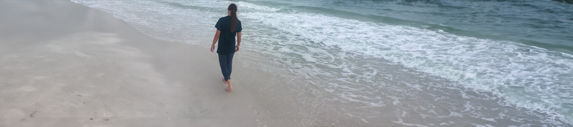 Grace Maxwell walking away from the camera on the beach.