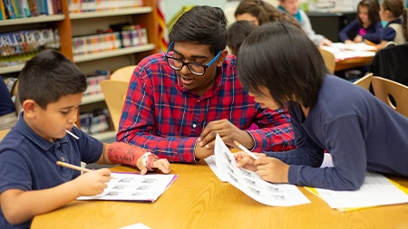 Student tutoring two elementary school students