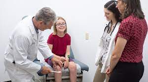 PA professor examines a girl while students look on.