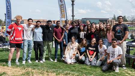Group of international students smiling together outside.