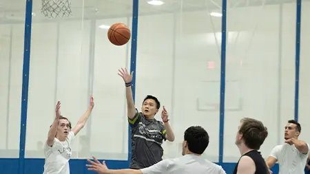 Group of male students playing intramural basketball game