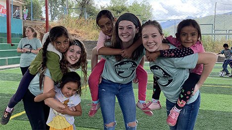 Cedarville students playing with kids in outdoor gym