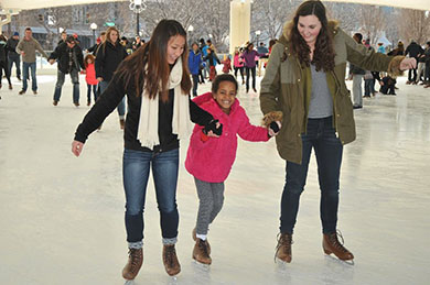 Students ice skating with young lady