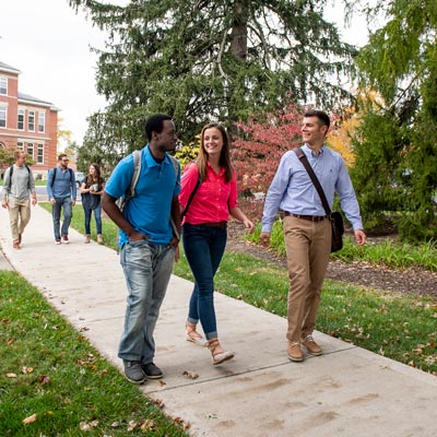 Three diverse students walking on a sidewalk at Cedarville