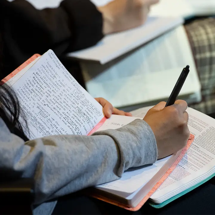 Someone writing in a notebook