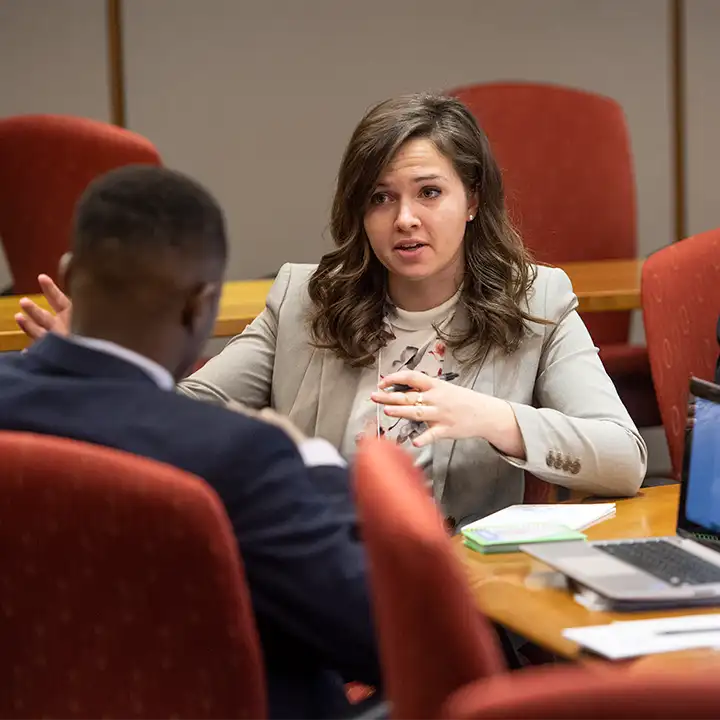 Man and woman in business attire sitting and talking