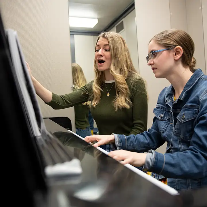 Two women sitting at a piano